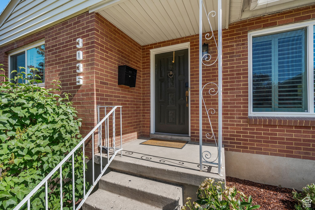 View of exterior entry with brick siding