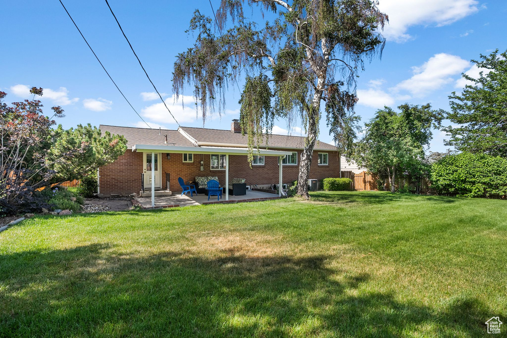 Rear view of house featuring a patio and brick siding