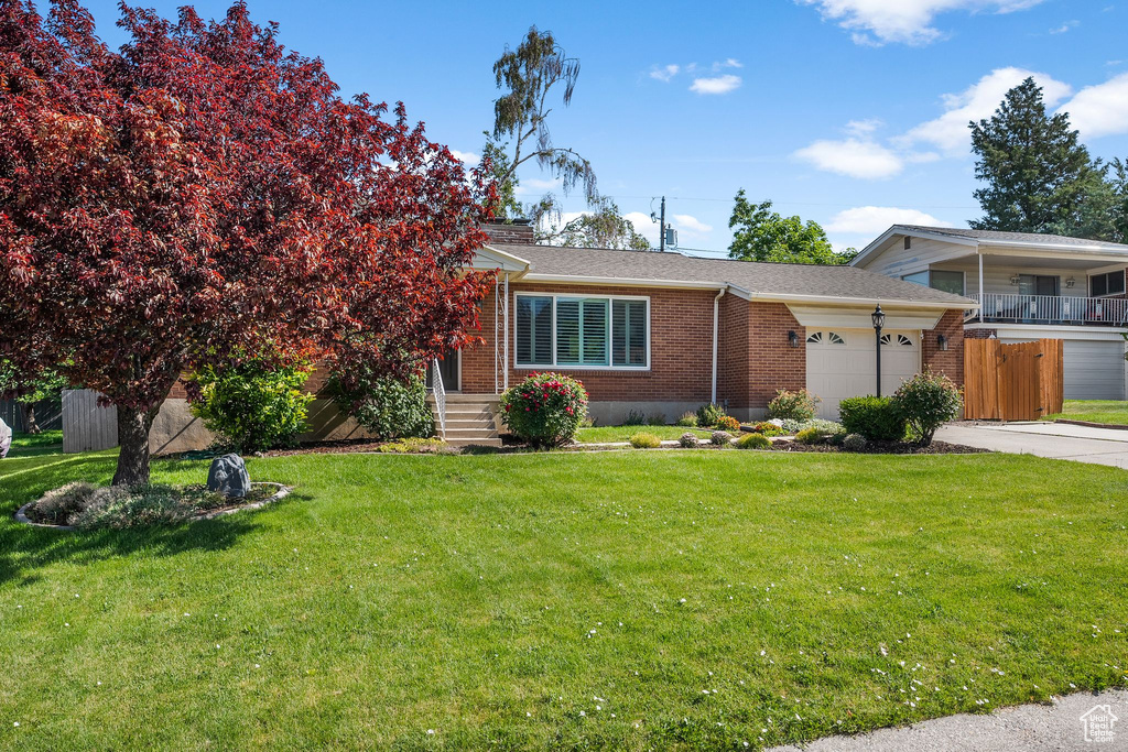 Tri-level home with brick siding, a garage, concrete driveway, and roof with shingles