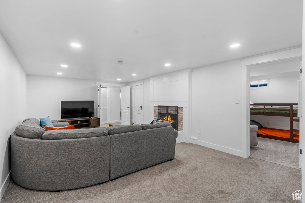 Carpeted living area with recessed lighting and a brick fireplace
