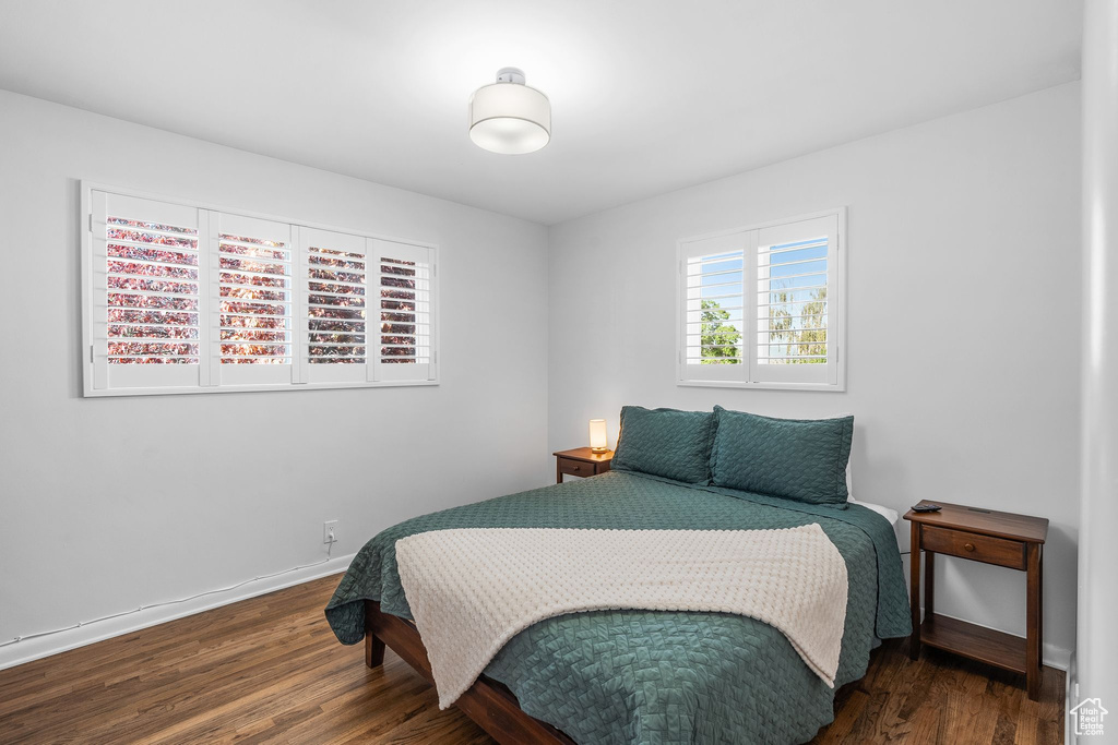 Bedroom with dark wood-style floors and baseboards