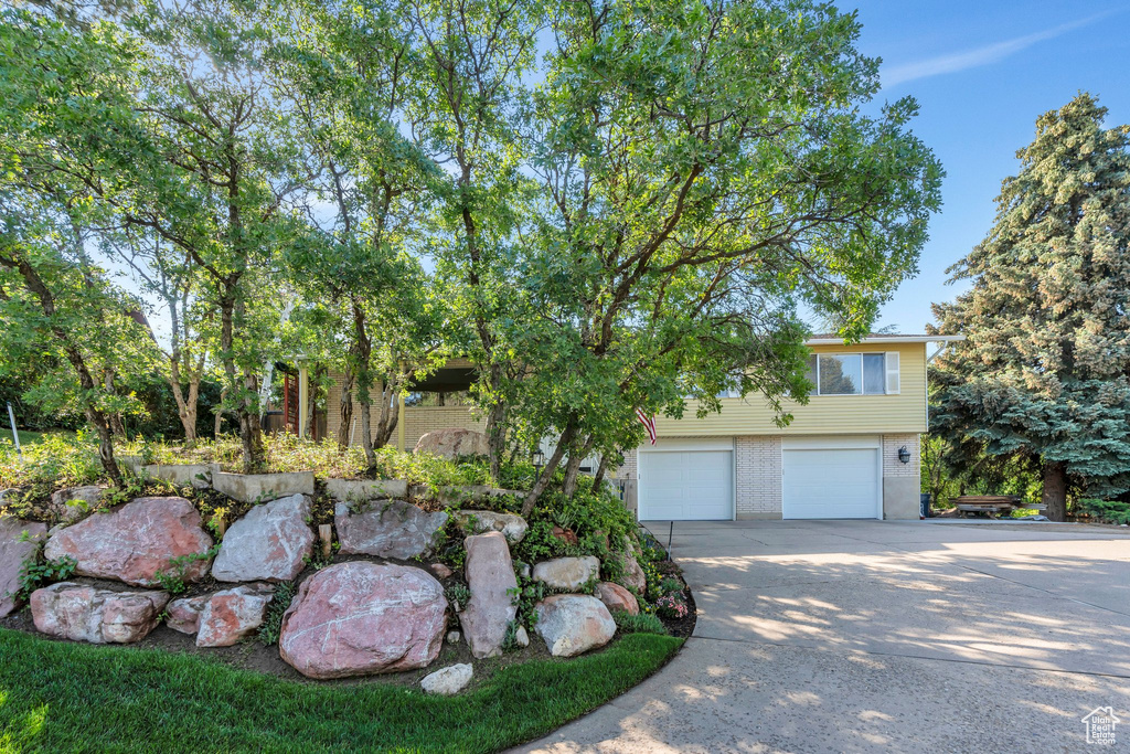 View of front of property with concrete driveway, an attached garage, and brick siding