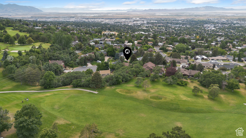 Aerial perspective of suburban area with a mountain backdrop and a local golf course
