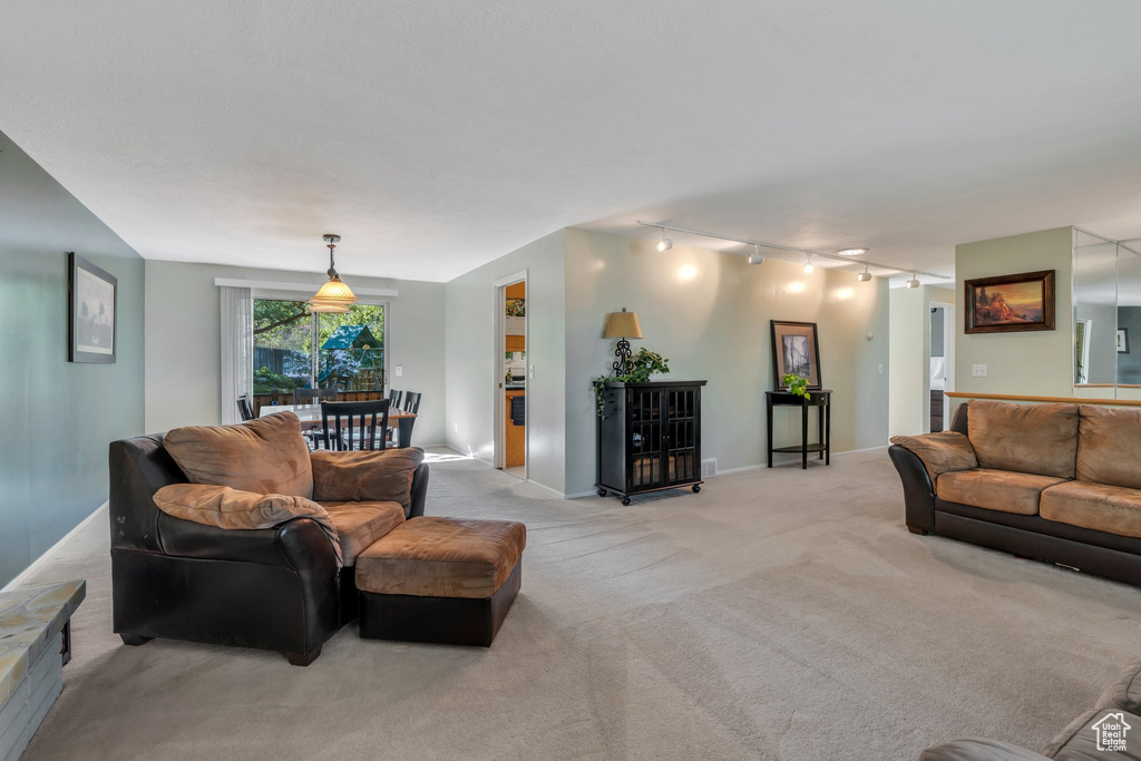 Living room with rail lighting and light colored carpet