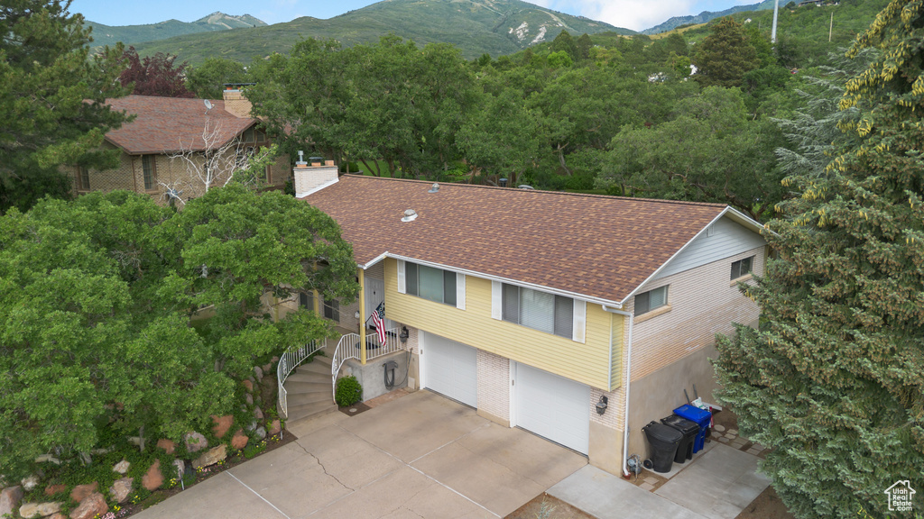 Aerial view of property and surrounding area featuring a mountain backdrop