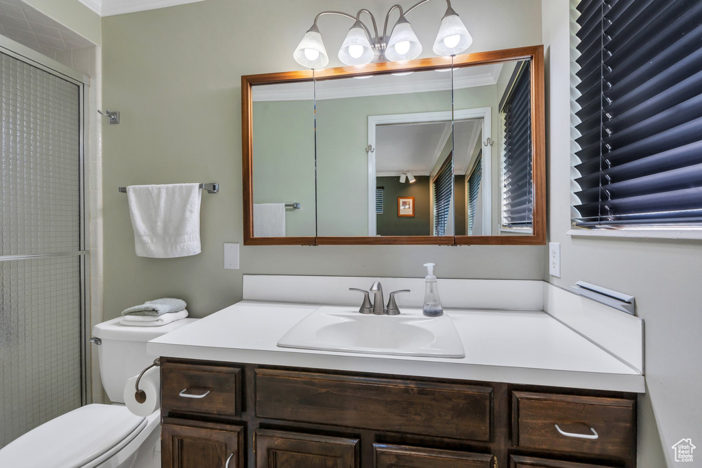 Full bath with vanity, an enclosed shower, and ornamental molding