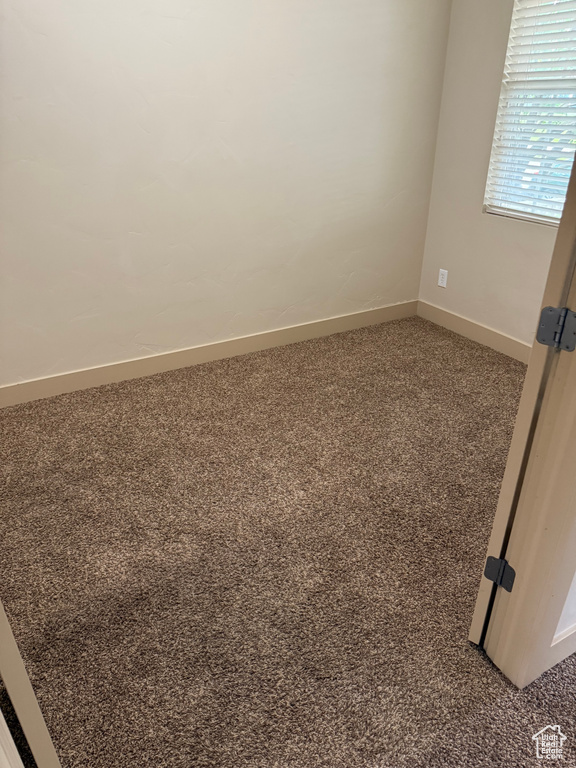 Carpeted empty room with baseboards