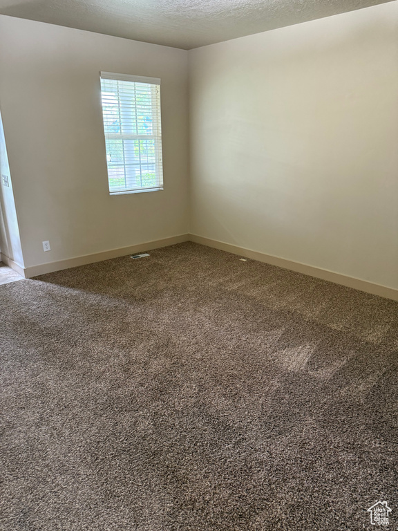 Carpeted empty room featuring baseboards