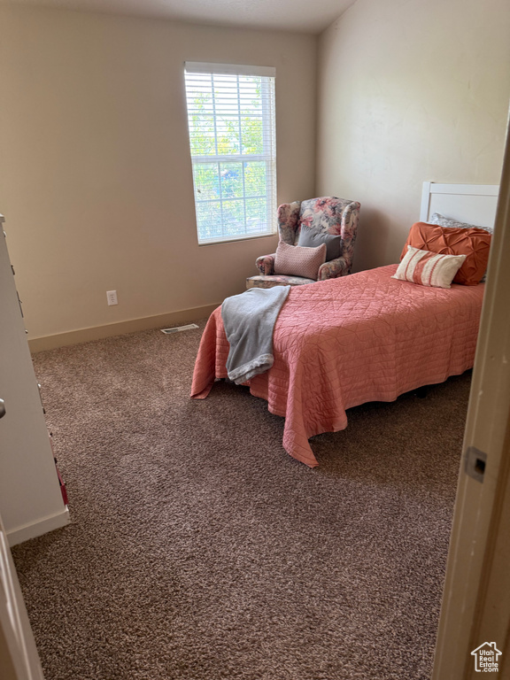 Bedroom featuring carpet floors and baseboards