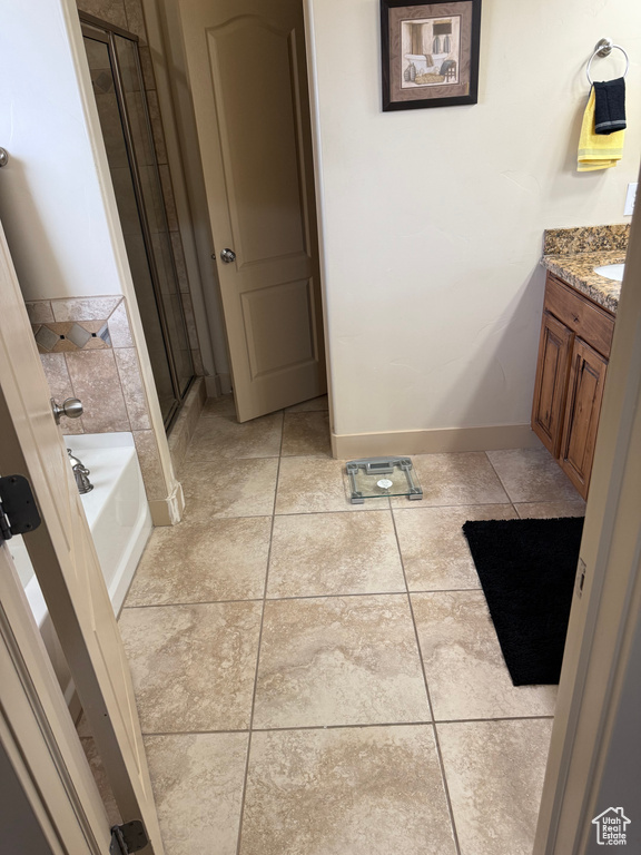 Bathroom with a stall shower, a bath, vanity, and tile patterned floors