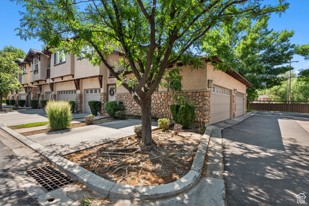 View of front of home with stucco siding, stone siding, and a residential view