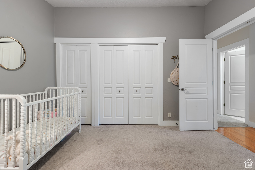 Bedroom featuring carpet floors and a crib