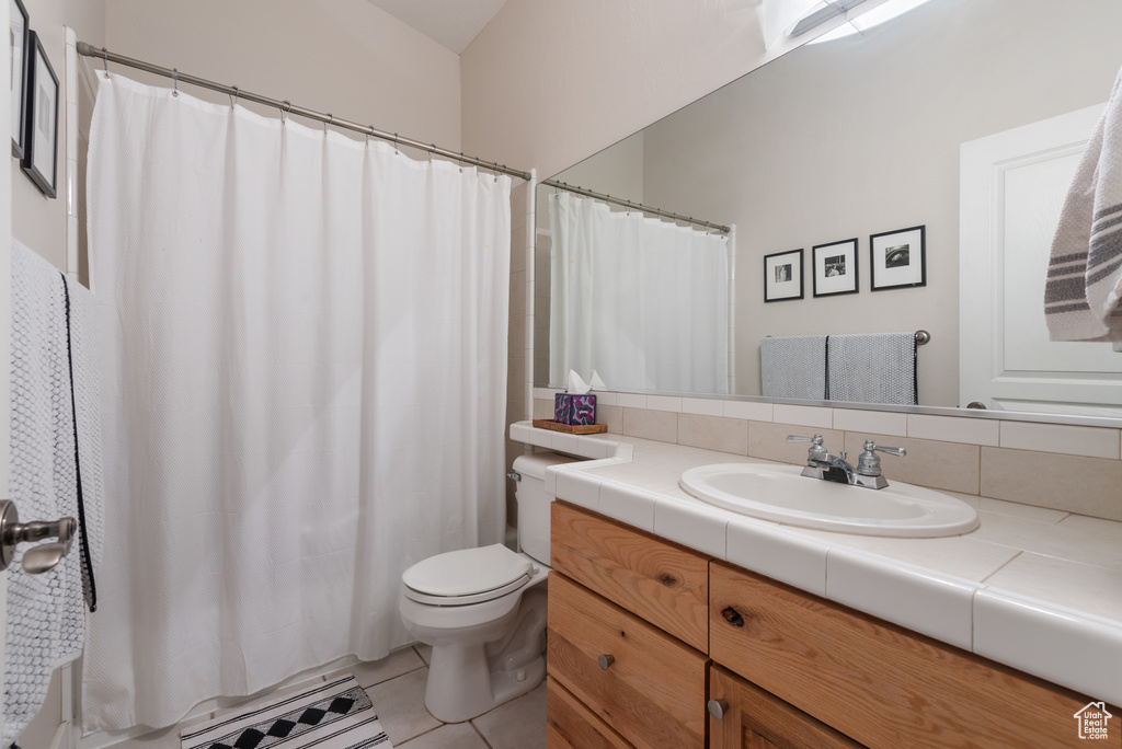 Full bath featuring vanity, tile patterned flooring, and curtained shower