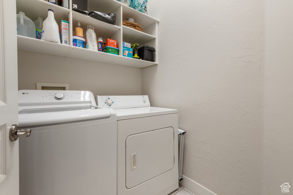 Laundry room with washer and dryer and a textured wall