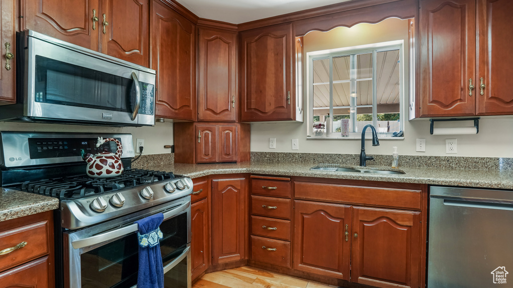 Kitchen with stainless steel appliances and brown cabinetry
