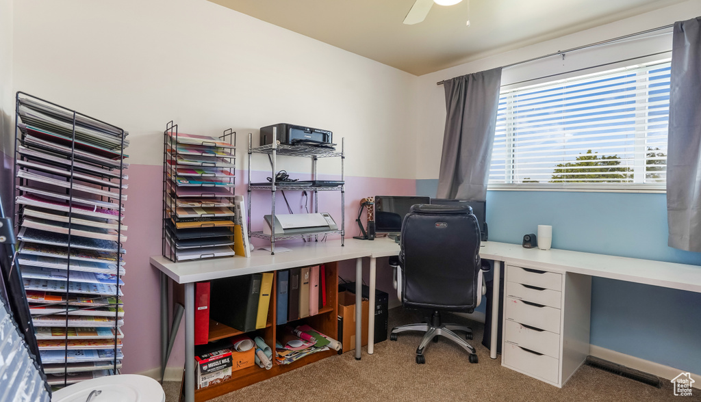 Carpeted office space featuring a ceiling fan