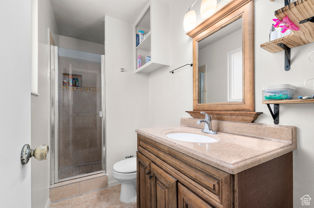Full bathroom with vanity, a stall shower, and tile patterned floors