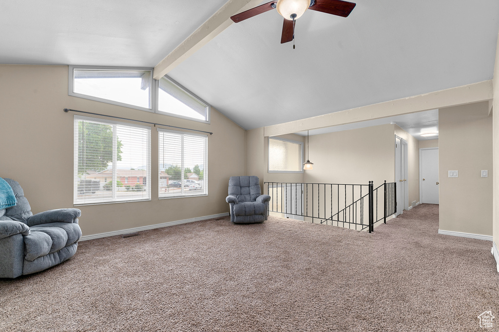 Living area featuring carpet flooring, a ceiling fan, and an upstairs landing