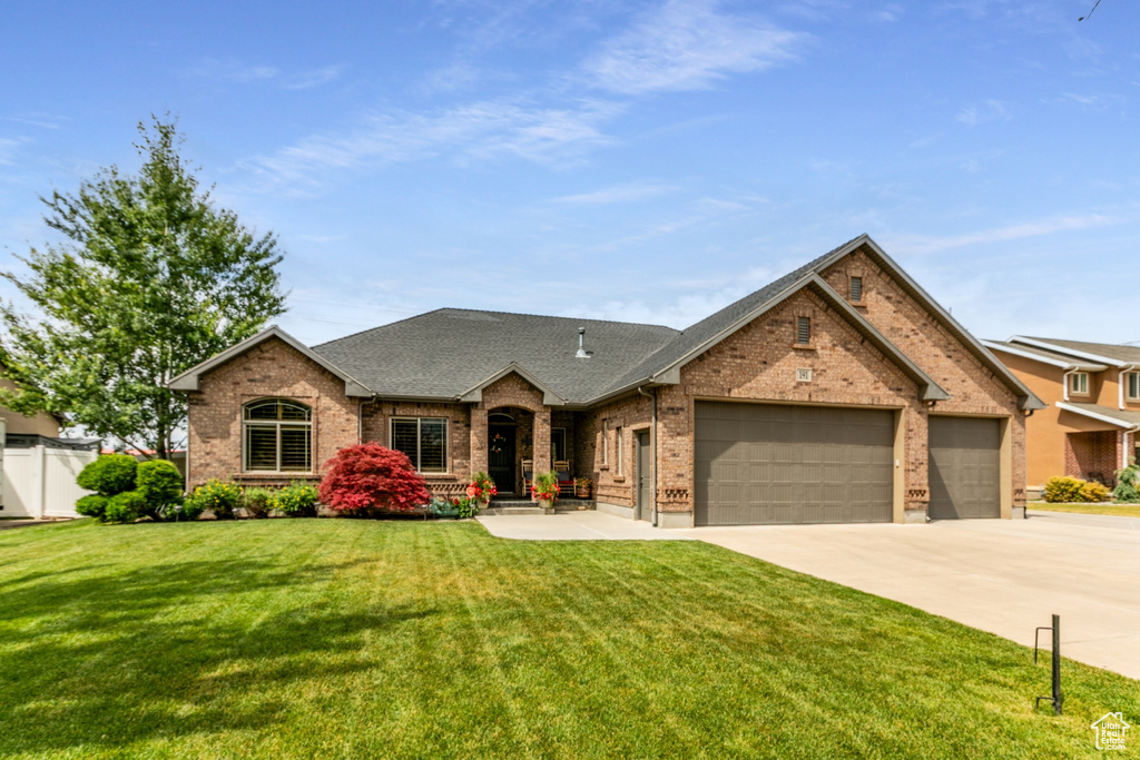 View of front facade featuring brick siding, an attached garage, concrete driveway, and roof with shingles