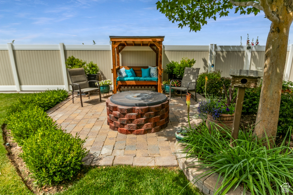 Fenced backyard with an outdoor fire pit and a patio