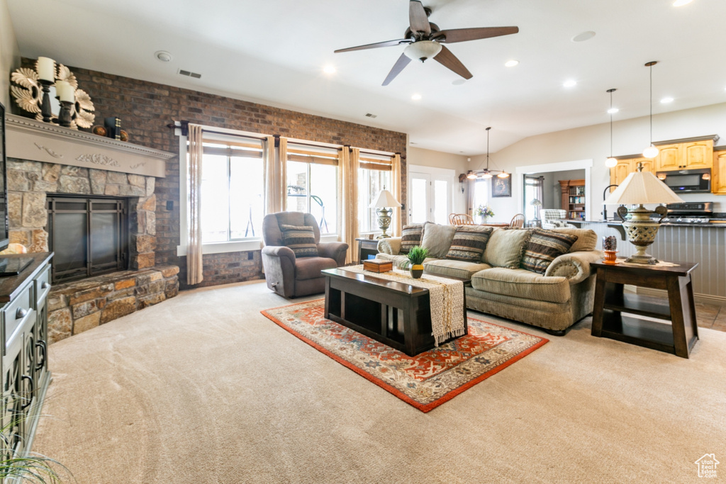 Living area with light carpet, plenty of natural light, ceiling fan, a fireplace, and recessed lighting