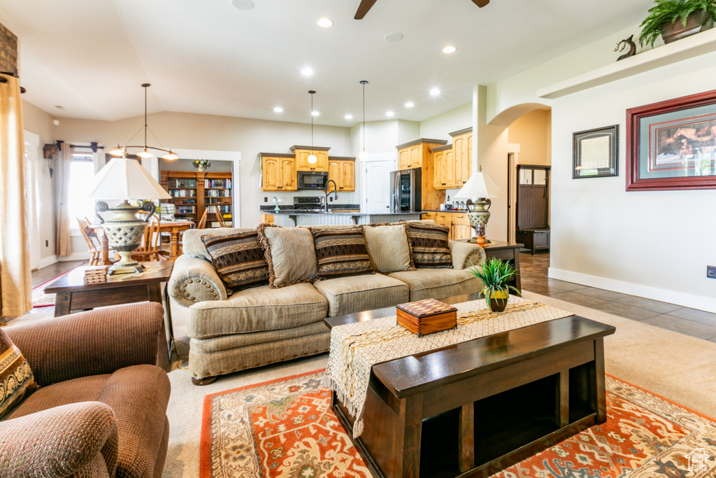 Living room with arched walkways, a ceiling fan, and recessed lighting