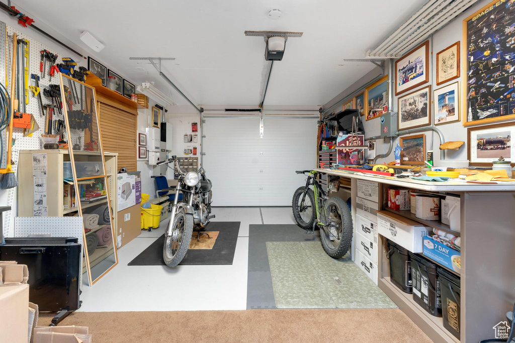 Garage featuring a garage door opener and a workshop area