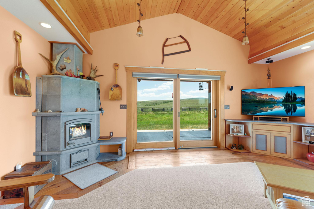 Living room featuring a wood stove, wood ceiling, hardwood / wood-style flooring, high vaulted ceiling, and recessed lighting