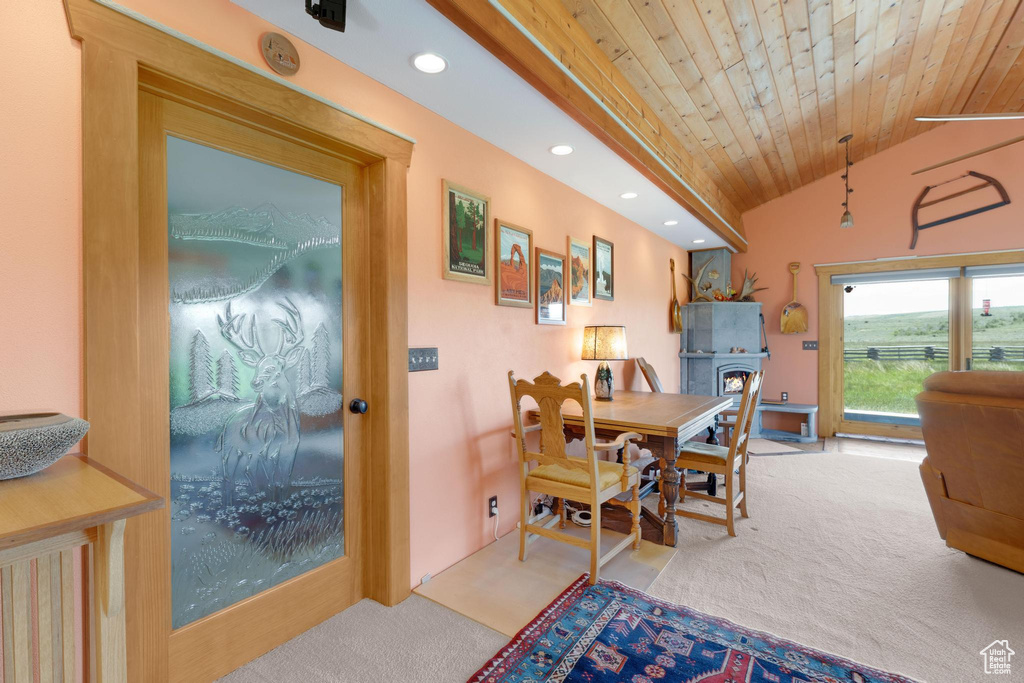 Dining space with carpet, recessed lighting, wood ceiling, lofted ceiling, and a warm lit fireplace