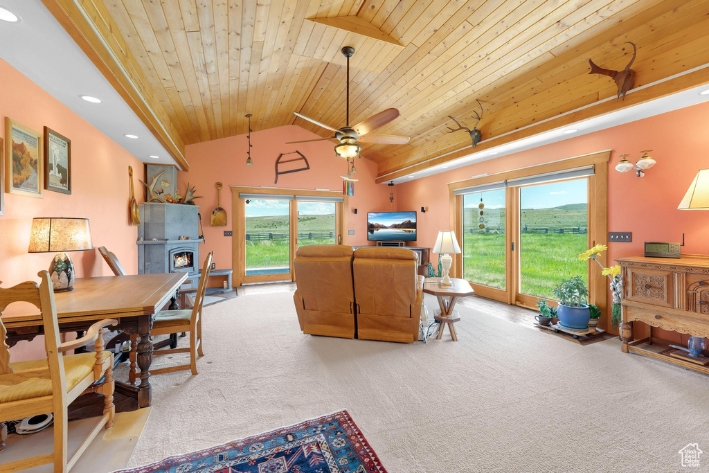 Living room with wooden ceiling, carpet flooring, recessed lighting, a warm lit fireplace, and lofted ceiling