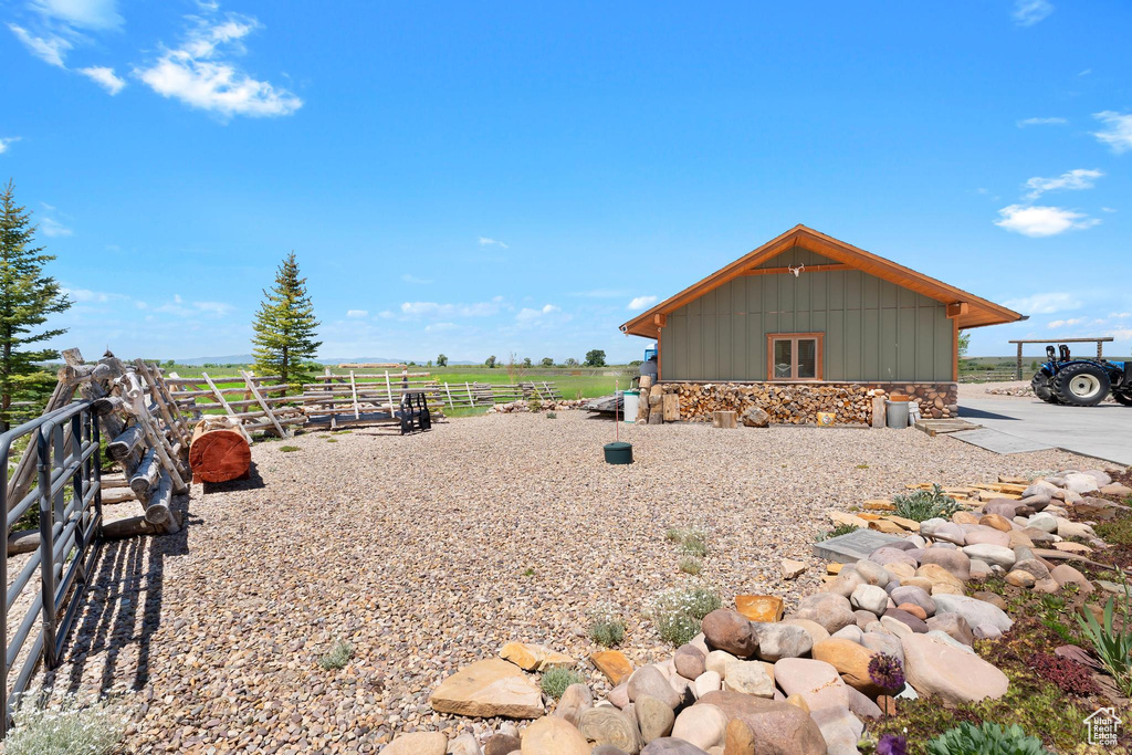 View of home's exterior with board and batten siding, stone siding, and a view of rural / pastoral area