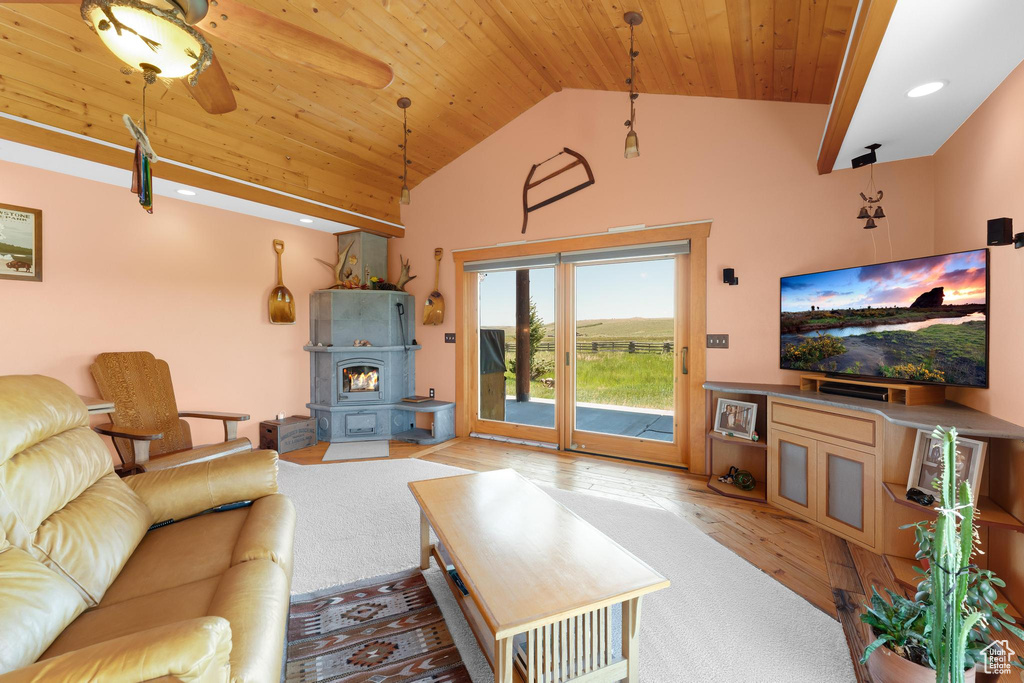 Living area featuring a wood stove, wooden ceiling, wood finished floors, high vaulted ceiling, and recessed lighting