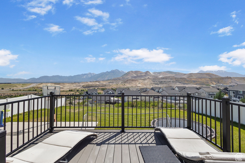 Deck featuring a residential view, a mountain view, and a yard