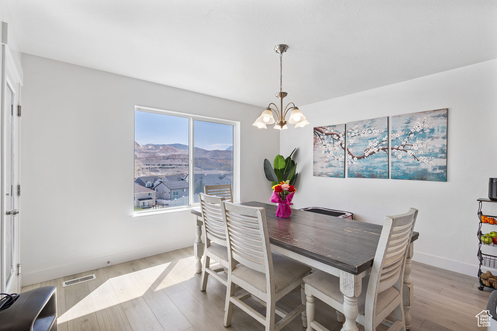 Dining room with a chandelier, light wood-type flooring, and a mountain view