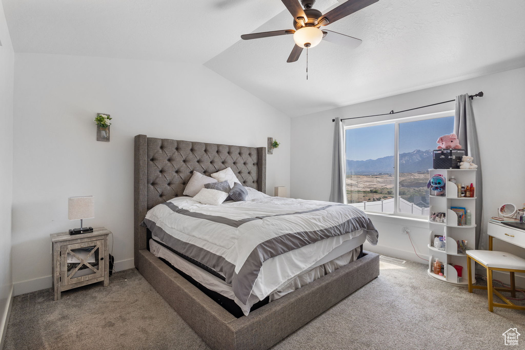 Bedroom with carpet flooring, vaulted ceiling, a mountain view, and ceiling fan