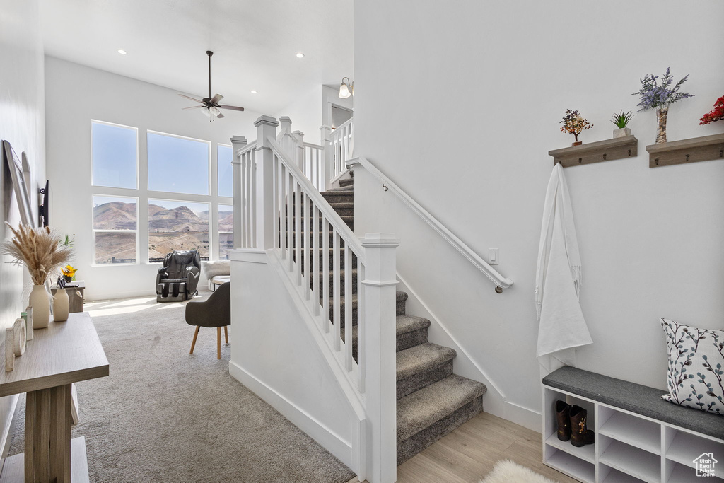 Staircase featuring ceiling fan, recessed lighting, and a high ceiling