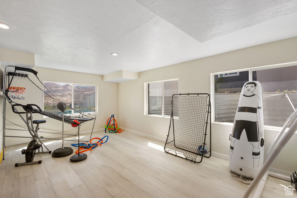 Workout area featuring wood finished floors, a textured ceiling, and recessed lighting