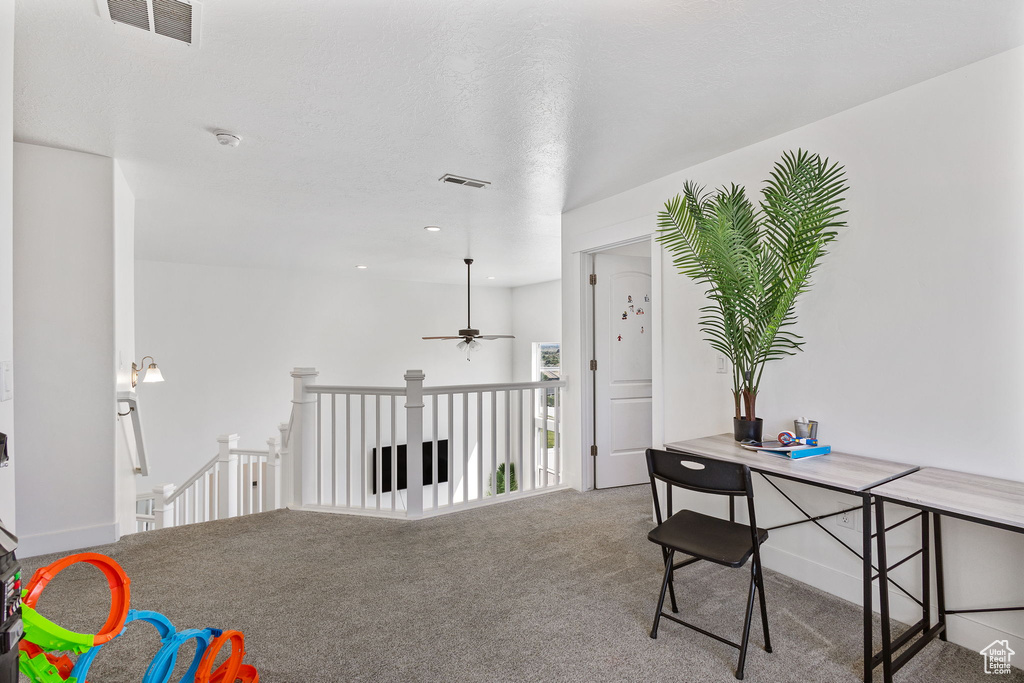 Hall with carpet floors and an upstairs landing