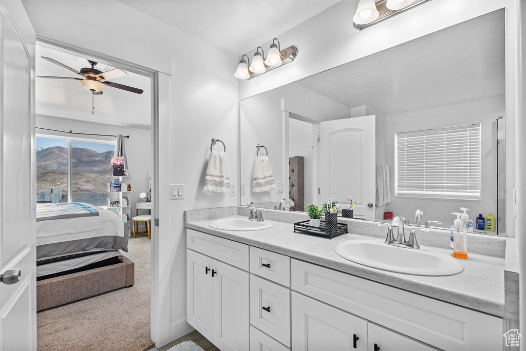 Bathroom with double vanity, ceiling fan, and ensuite bath