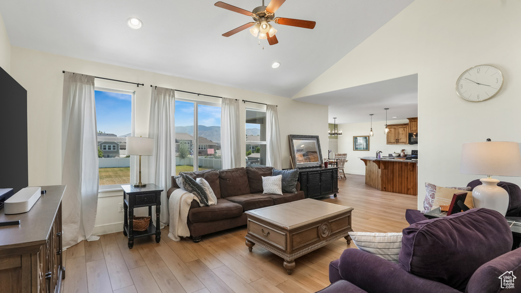 Living room featuring ceiling fan, light wood-style flooring, recessed lighting, and high vaulted ceiling