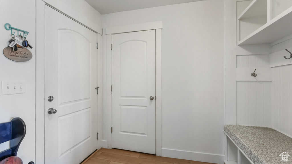 Mudroom featuring light wood-style flooring and baseboards