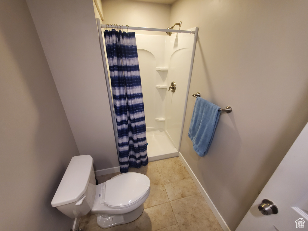 Bathroom featuring a shower stall and tile patterned flooring