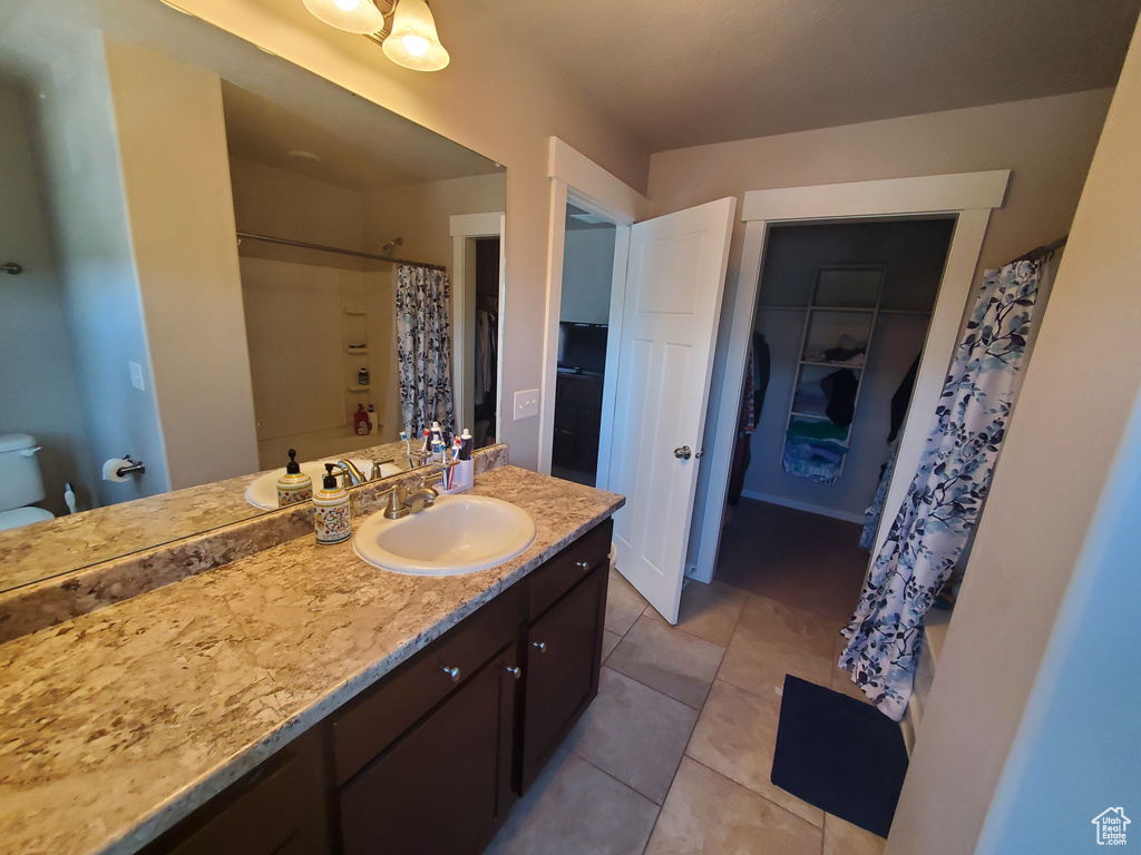 Bathroom with vanity, tile patterned floors, and a shower with shower curtain