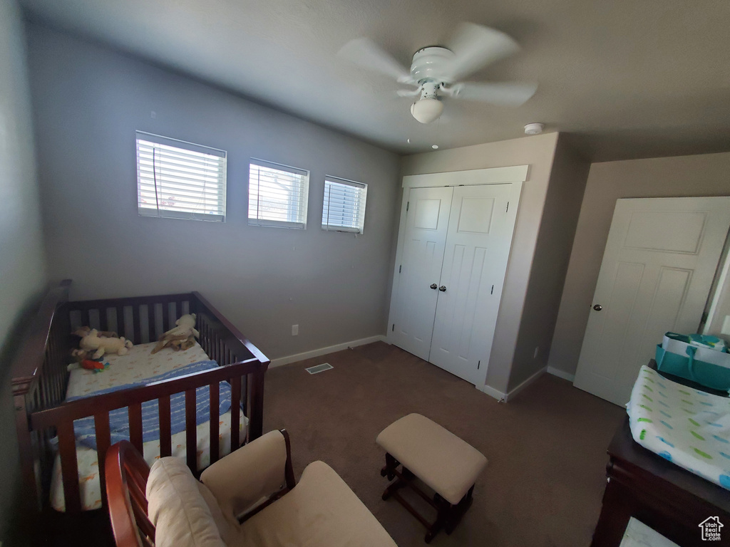Carpeted bedroom with a closet and a ceiling fan