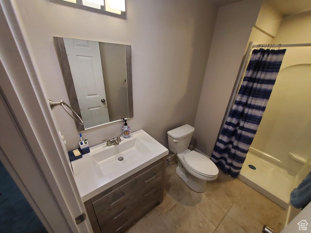 Bathroom featuring a shower with curtain, vanity, and tile patterned floors