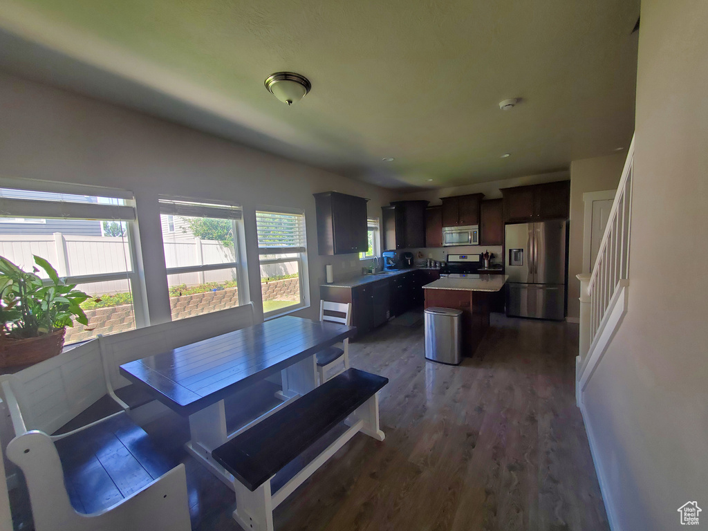 Dining area with dark wood-type flooring and stairway