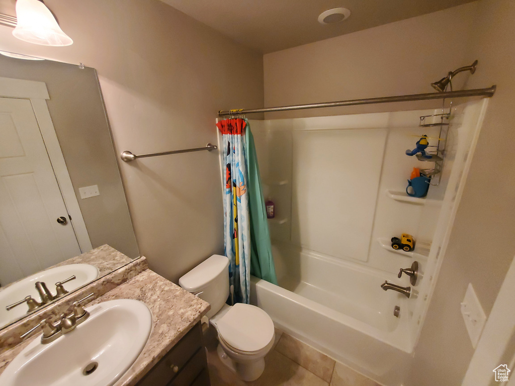 Bathroom featuring shower / tub combo with curtain, vanity, and tile patterned floors
