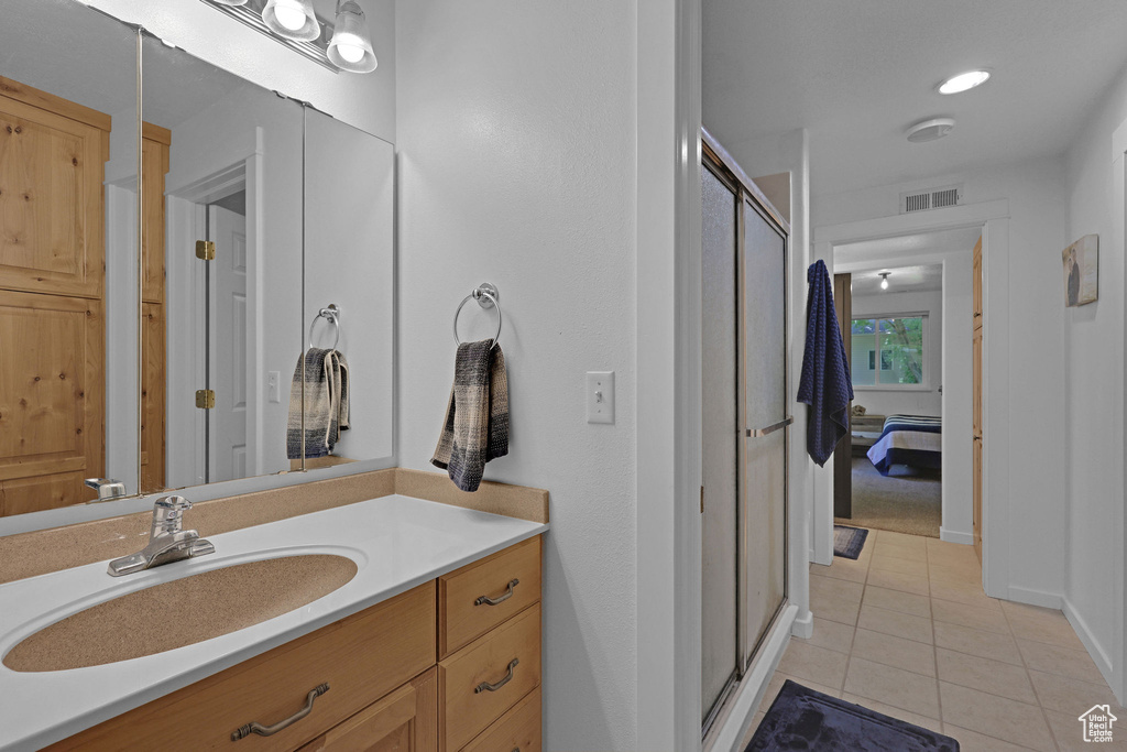 Bathroom with tile patterned flooring, vanity, a shower stall, and connected bathroom
