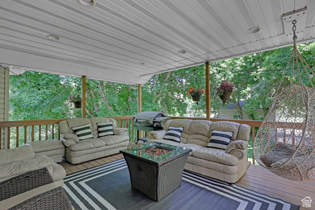 Wooden terrace featuring an outdoor living space with a fire pit and a grill