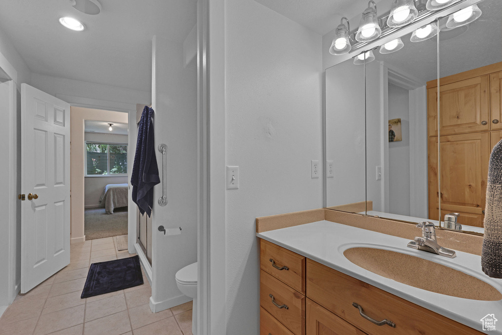 Ensuite bathroom with tile patterned floors and vanity